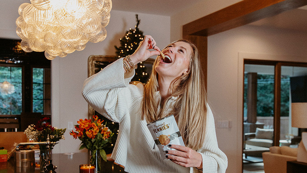 Woman sitting on a kitchen counter eating popcorn with a modern interior background