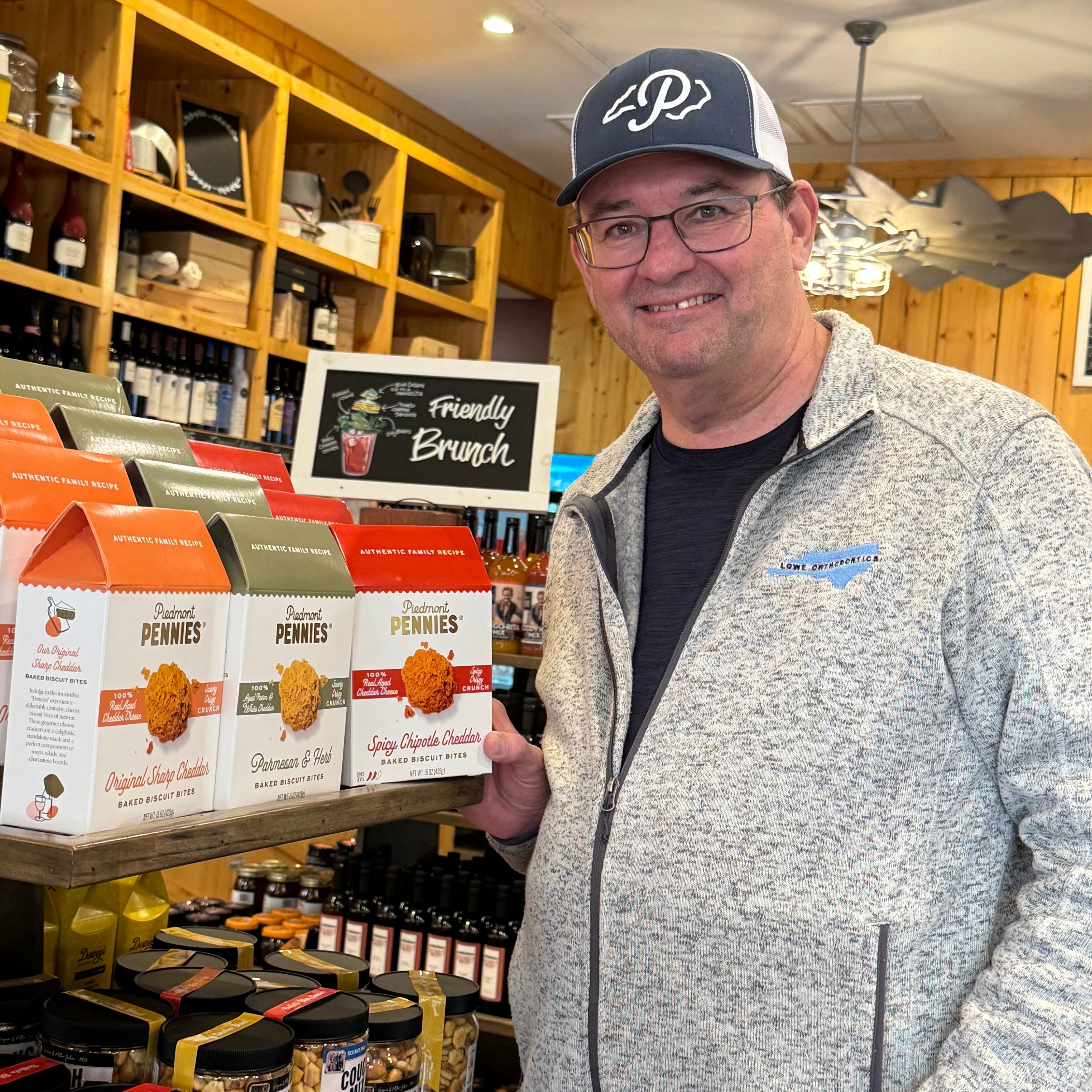 Man holding a tray of food products in a store setting